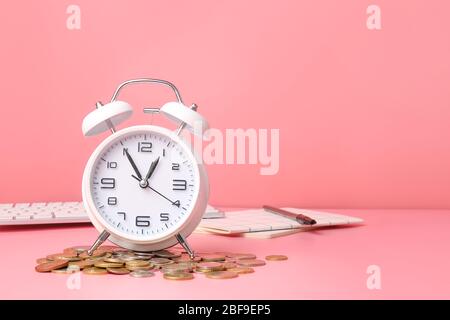 Réveil et pièces sur fond couleur. Concept de gestion du temps Banque D'Images