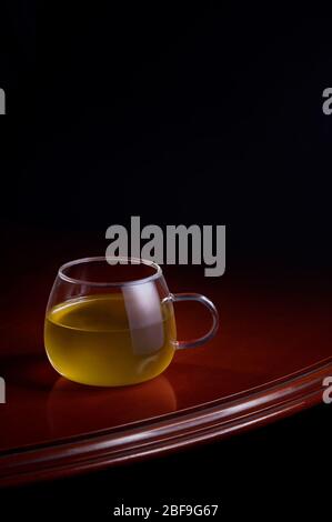 Tasse de perfusion jaune sur une table luxueuse avec un fond noir Banque D'Images