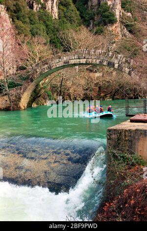 Rafting en rivière Voidomatis sous le vieux pont voûté de la Kleidonia, gorge de Vikos, région de Zagori, préfecture de Ioannina, Épire, Grèce. Banque D'Images