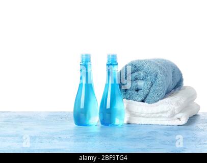 Shampooing et serviettes sur table sur fond blanc Banque D'Images