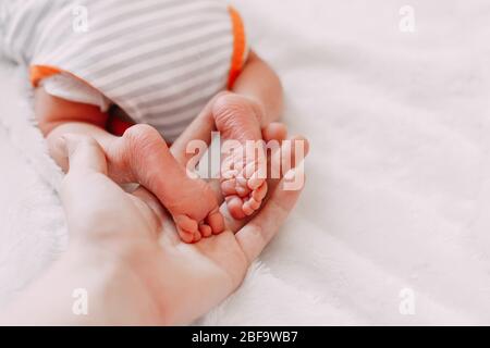 Pieds de bébé dans les mains de la mère. Les pieds de bébé nouveau-né se rapprochez les mains en forme de coeur. Maman et son enfant. Concept de famille heureuse. Beau pho conceptuel Banque D'Images