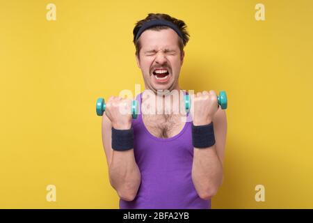 Un homme fou et drôle, essayez de soulever une petite cloche bleue. Gardez un concept de quarantaine solide. Banque D'Images