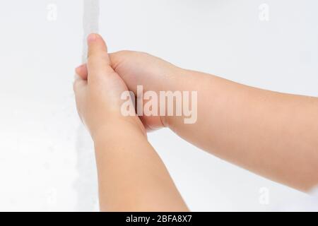 Enfant de 3 à 5 ans se lave les mains sous le robinet. Traitement des mains en quarantaine en relation avec le coronavirus COVID-19 Banque D'Images