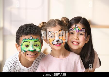 Petits enfants drôles avec peinture de visage à la maison Banque D'Images