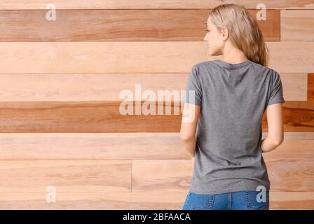 Femme dans un t-shirt élégant sur fond en bois Banque D'Images