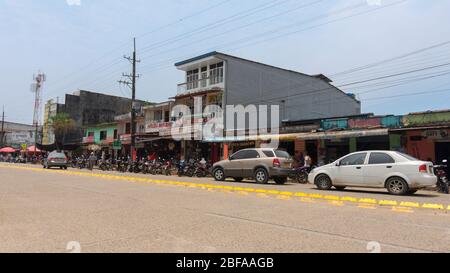 La Dorada, Putumayo / Colombie - 8 mars 2020: Les gens marchent sur la route principale pleine de motos et de voitures circulant une journée ensoleillée Banque D'Images