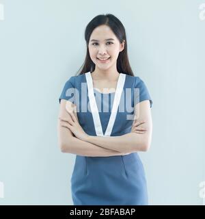 Portrait d'une femme d'affaires asiatique souriante debout avec des bras repliés et regardant un appareil photo isolé sur fond gris Banque D'Images