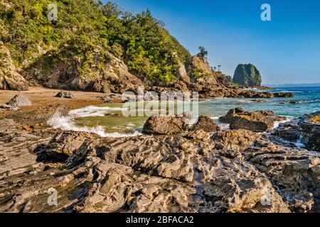 Roches volcaniques sur la plage de Poley Bay, péninsule de Coromandel, région de Waikato, Île du Nord, Nouvelle-Zélande Banque D'Images