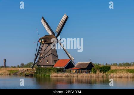 Vue aérienne d'un ancien moulin à vent traditionnel néerlandais sur la campagne rurale des Pays-Bas avec une digue, des canaux, un pont et des champs. Banque D'Images