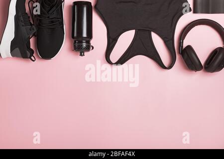 Accessoires de fitness en couleur noire sur fond rose. Banque D'Images