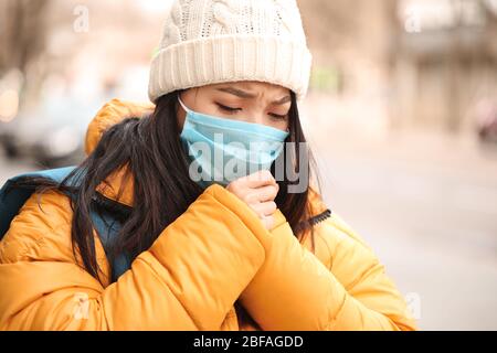 Toussez une femme asiatique dans un masque de protection sur la rue de la ville. Concept d'épidémie Banque D'Images