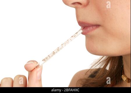 Une femme avec un thermomètre au mercure dans sa bouche. Elle prend sa propre température pour diagnostiquer les symptômes de la grippe (grippe). Elle utilise un Banque D'Images