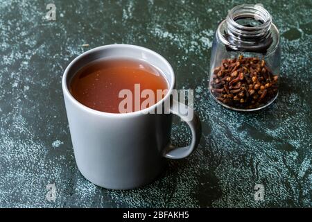 Sumac eau ou thé et épices sumac rouges secs moulues avec clous de girofle en verre. Prêt à boire. Banque D'Images