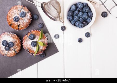 De délicieux muffins aux bleuets sur la table en bois blanc Banque D'Images