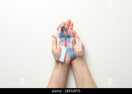 Les mains des femmes tiennent le ruban de sensibilisation au diabète sur fond blanc Banque D'Images