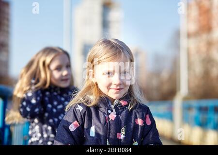 Adorables enfants en jaket bleu se posant à l'extérieur. Les filles s'amusent ensemble. Petites filles de bébé dans le parc. Vacances de printemps ou d'automne Banque D'Images