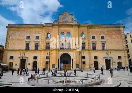 Matera, Italie - 6 mai 2018: Les gens marchent près du palais du Cinéma Comunale Palazzo dell'Annunziata avec horloge sur la façade et fontaine sur la Piazza Vittorio V Banque D'Images