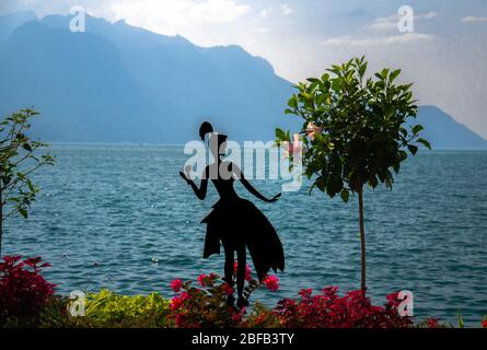 Montreux, Suisse - 14 septembre 2017 : silhouette de fille près de l'arbre et des fleurs sur la promenade du lac Léman (lac Léman) en fro Banque D'Images