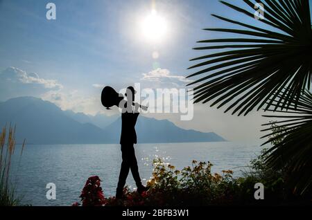 Montreux, Suisse - 14 septembre 2017 : silhouette figurée de l'homme avec guitare et fleurs sur la promenade du lac Léman (lac Léman) devant Banque D'Images