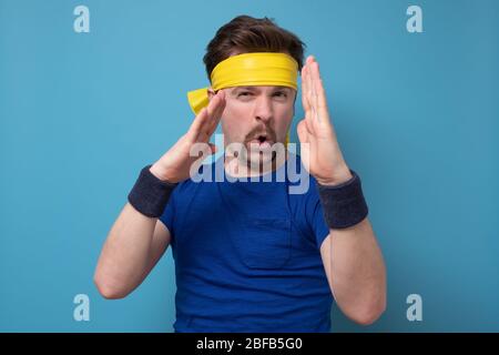 Un homme adulte séduisant et sérieux avec moustache montre un geste de hache carate isolé sur fond bleu Banque D'Images