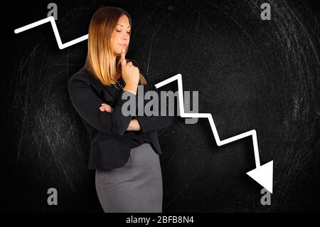 Une femme d'affaires s'inquiète de la perte de cartes derrière le tableau de surveillance. Une femme d'affaires autiful s'inquiète des pertes d'entreprise. Banque D'Images