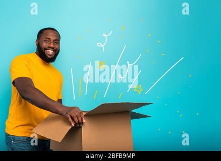 Happy boy reçoit un forfait de l'ordre de fabrication en ligne. Fond bleu. Banque D'Images