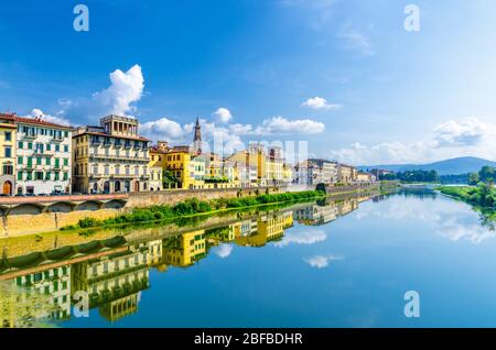 Arno River bleu réfléchissant l'eau et les bâtiments sur la promenade du remblai dans le centre historique de Florence, ciel bleu nuages blancs, Toscane, Italie Banque D'Images