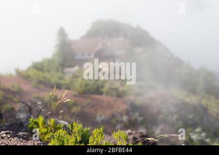 Une maison blanche avec un toit carrelé dans les montagnes parmi les nuages. Banque D'Images