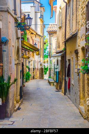 Rue pavée italienne typique avec bâtiments et maisons traditionnels avec des plantes vertes sur les murs dans le vieux centre historique de Saint-Marin Banque D'Images