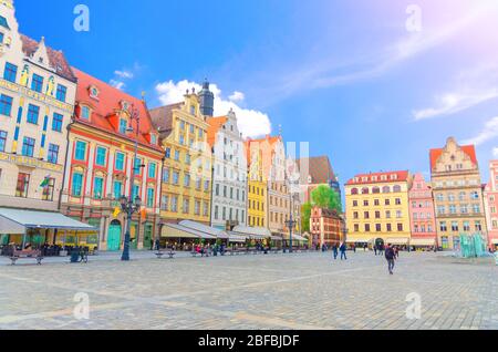 Rangée de bâtiments traditionnels colorés avec façades d'art multicolores et personnes marchant sur la place du marché de Rynek dans le centre historique de la vieille ville de WR Banque D'Images