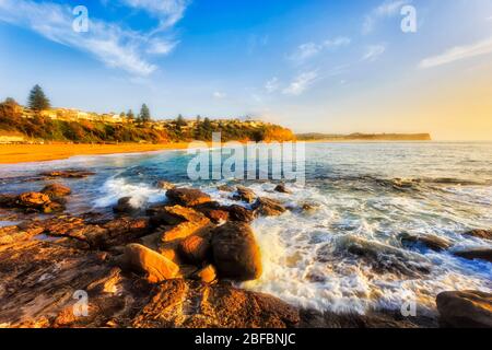 Plage de Warriewood au lever du soleil, face au nord, sur la côte du Pacifique de Sydney. Banque D'Images