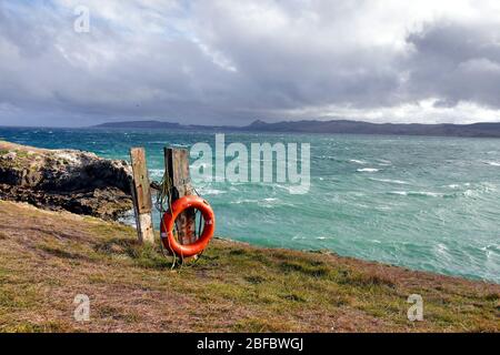 Anneau de bouée de sauvetage orange sur la falaise avec mer turquoise en arrière-plan. Nouvelle-Zélande, île du Sud. Banque D'Images