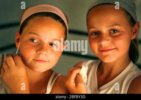 Deux filles vérifiant leurs visages pour des taches. Banque D'Images