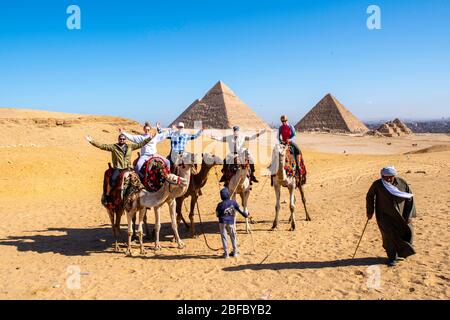 Une famille manèges chameaux au complexe Giza Pyramid, Giza, Egypte. Banque D'Images