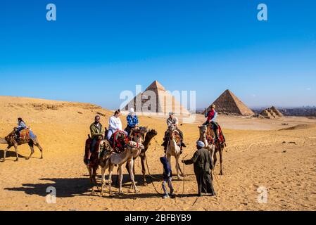 Une famille manèges chameaux au complexe Giza Pyramid, Giza, Egypte. Banque D'Images