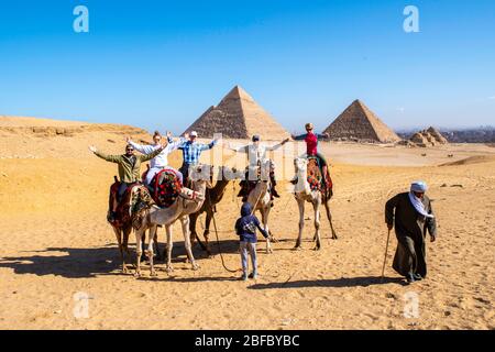 Une famille manèges chameaux au complexe Giza Pyramid, Giza, Egypte. Banque D'Images