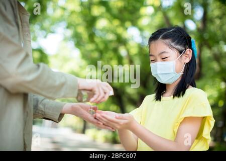 mère et fille utilisant du gel désinfectant pour les mains Banque D'Images