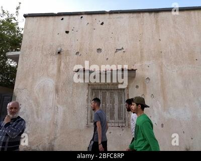 Tripoli, Libye. 17 avril 2020. Les gens passent par une maison endommagée après un bombardement à Tripoli, en Libye, le 17 avril 2020. Vendredi, des bombardements aveugles ont frappé des zones résidentielles dans différentes parties de la capitale libyenne Tripoli, tuant deux civils, un responsable local a déclaré Xinhua. Crédit: Hamza Turkia/Xinhua/Alay Live News Banque D'Images