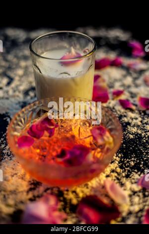 Masque de visage de farine de blé pour peau huileuse sur un panneau de couleur noire composé d'une certaine eau de rose, de lait, de farine de blé et de miel brut pour peau huileuse. Photo de tous Banque D'Images