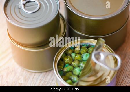 Conserves de nourriture en métal sur fond de bois , vue de dessus / conserves de marchandises non périssables stockage de nourriture dans la maison de cuisine , pois en conserve Banque D'Images