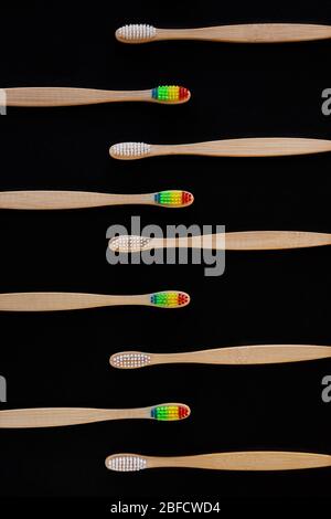 Groupe de brosses à dents en bambou ECO blanc et arc-en-ciel, sur fond noir. Vue de dessus. Produit biologique naturel pour l'hygiène buccale. Zéro déchet dentaire et non Banque D'Images