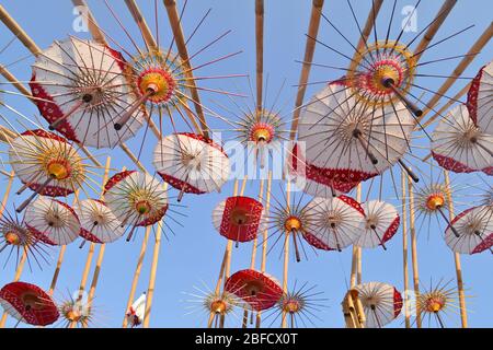 Des parasols et des motifs colorés sont suspendus dans l'air, vue de dessous. Le festival des parapluies à Solo avec une variété de parapluies traditionnels et modernes. Banque D'Images