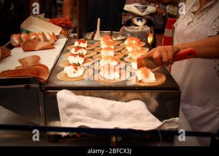 Un vendeur de cuisine de rue cuisinant et vendant des collations traditionnelles appelées khanom bueang ou crêpe croustillante thaïlandaise, montrant la culture et la cuisine locales de la Thaïlande Banque D'Images