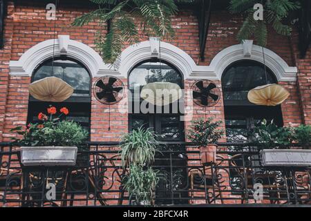 Bâtiment rustique balcon décoré avec des plantes de maison créant un espace de vie calme et relaxant dans le vieux quartier historique ou le quartier français à Hanoi Banque D'Images