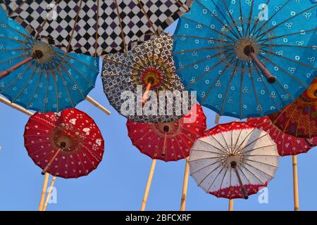 Des parasols et des motifs colorés sont suspendus dans l'air, vue de dessous. Le festival des parapluies à Solo avec une variété de parapluies traditionnels et modernes. Banque D'Images