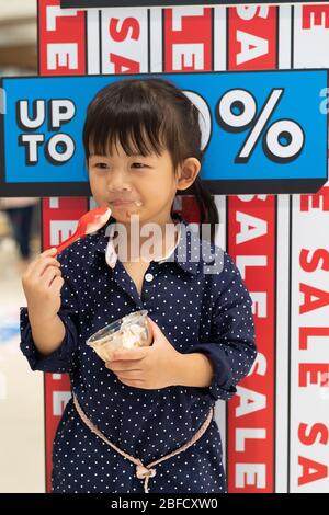 Une fille asiatique charmante qui aime avec une icarete dans le centre commercial. Banque D'Images