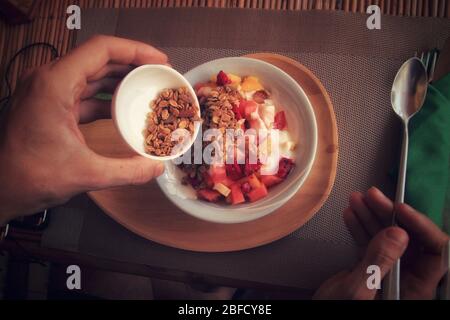 Petit déjeuner végétalien complet de fruits tropicaux smoothie bol avec muesli comme moyen de rester en bonne santé et de faire face pendant la quarantaine à domicile en raison de la pandémie de covid-19 Banque D'Images