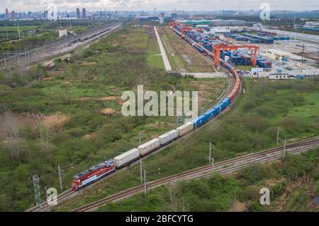 (200418) -- BEIJING, le 18 avril 2020 (Xinhua) -- une photo aérienne prise le 28 mars 2020 montre un train de marchandises Chine-Europe en direction de Duisburg, en Allemagne, qui sort du terminal Wuhan de l'Intermodal ferroviaire chinois à Wuhan, dans la province de Hubei en Chine centrale. (Xinhua/Xiao Yijiu) Banque D'Images