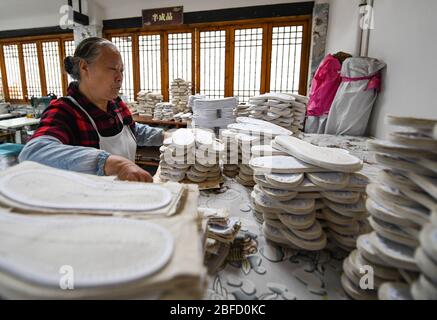 (200418) -- CHENGDU, 18 avril 2020 (Xinhua) -- Lai Shufang organise des semelles de chaussures faites main dans le village de Zhanqi, dans le canton de Tangchang, dans la province du Sichuan, dans le sud-ouest de la Chine, 17 avril 2020. Lai Shufang, 62 ans, est engagé dans la fabrication de chaussures Tangchang artisanales depuis plus de 40 ans. Dans le canton de Tangchang, la famille de Lai est la seule à avoir encore des chaussures en tissu Tangchang, qui présentent 32 procédures avant sa fin. Comme de nombreux artisans, Lai était autrefois inquiet que l'artisanat disparaisse et qu'il n'y aurait pas d'héritiers. Cependant, l'artisanat a ouvert sa voie Banque D'Images