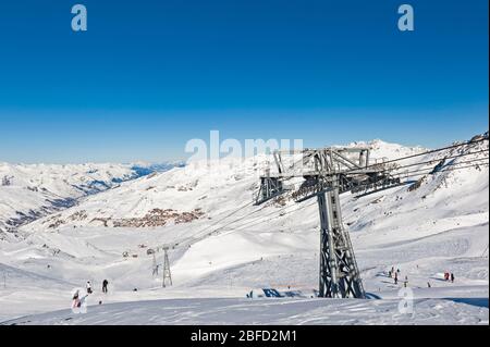 Vue panoramique sur la vallée enneigée de la station de ski alpin avec télésiège sur fond bleu ciel Banque D'Images